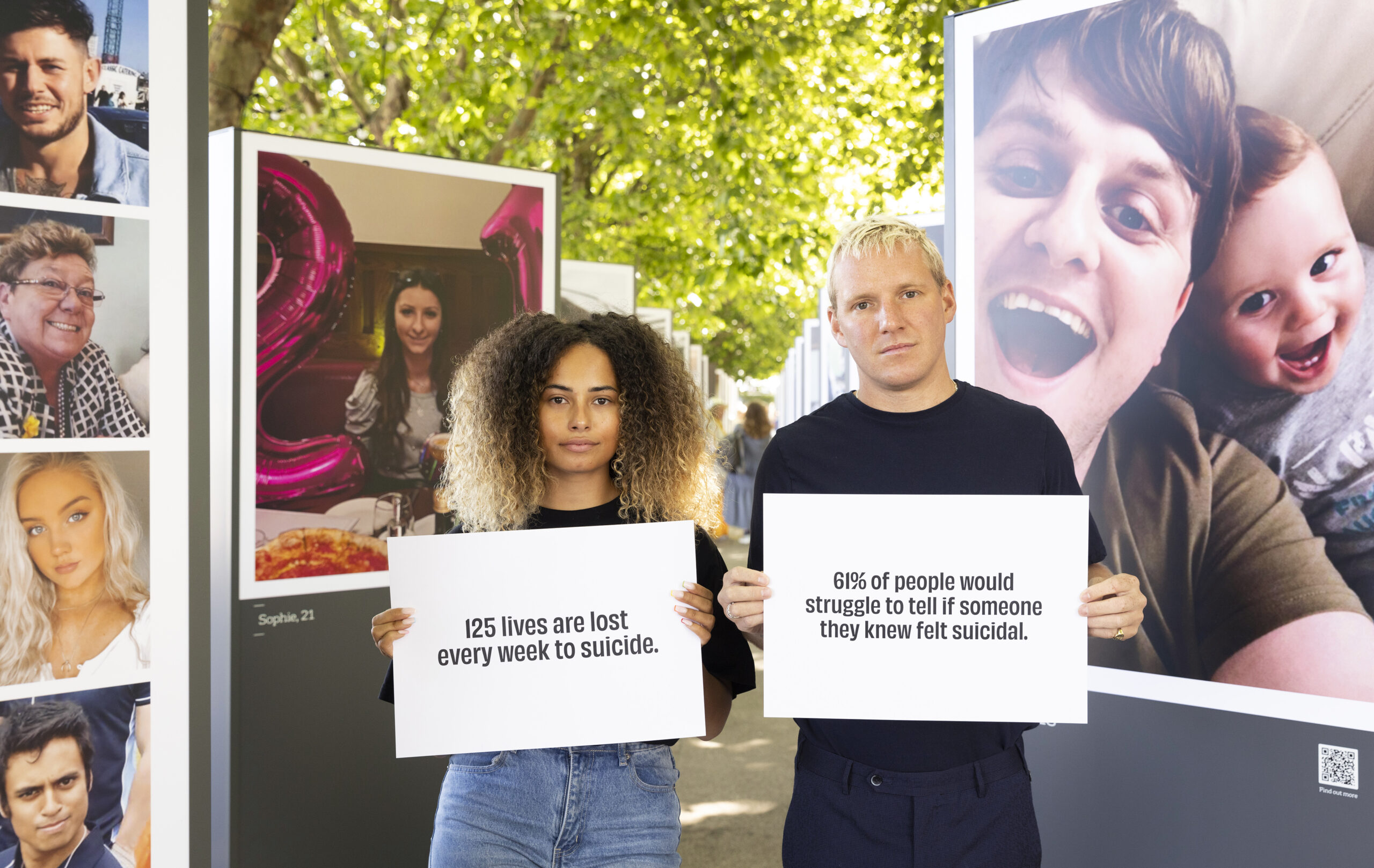 People standing with posters with devastating suicide stats